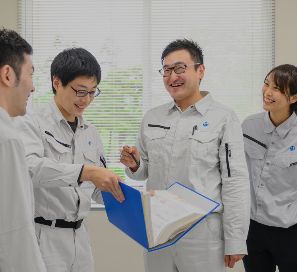 資料を広げてミーティングをする青木鐵工所社員4人
