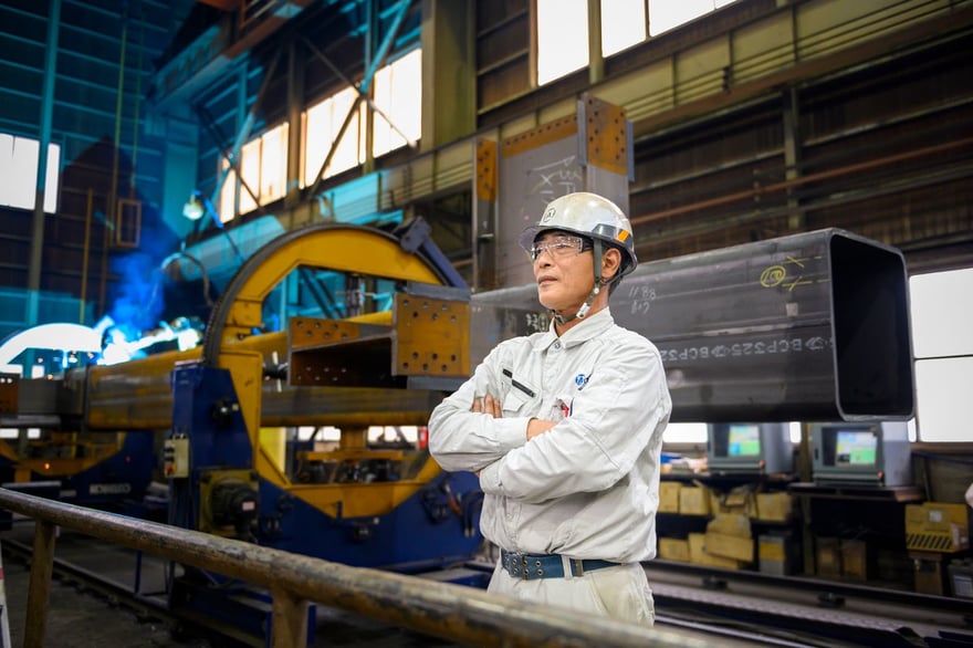 須坂工場で腕組みをする青木鐵工所の製造職社員